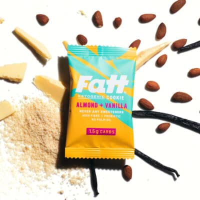 fatt almond vanilla keto cookie on a white background with ingredients like almond, butter and vanilla spread out around.