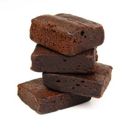 four fatt double chocolate brownies, stacked on a white background.