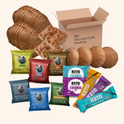 2 low carb loaves, 6 pork cracklings, 2 cookies, 3 keto bars, 4 low carb rolls and a cardboard box on a cream background