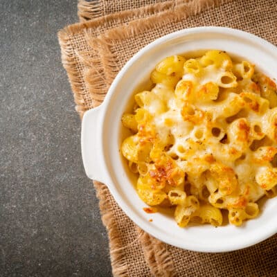 low-carb macaroni and cheese in a white baking dish on a burlap table cloth