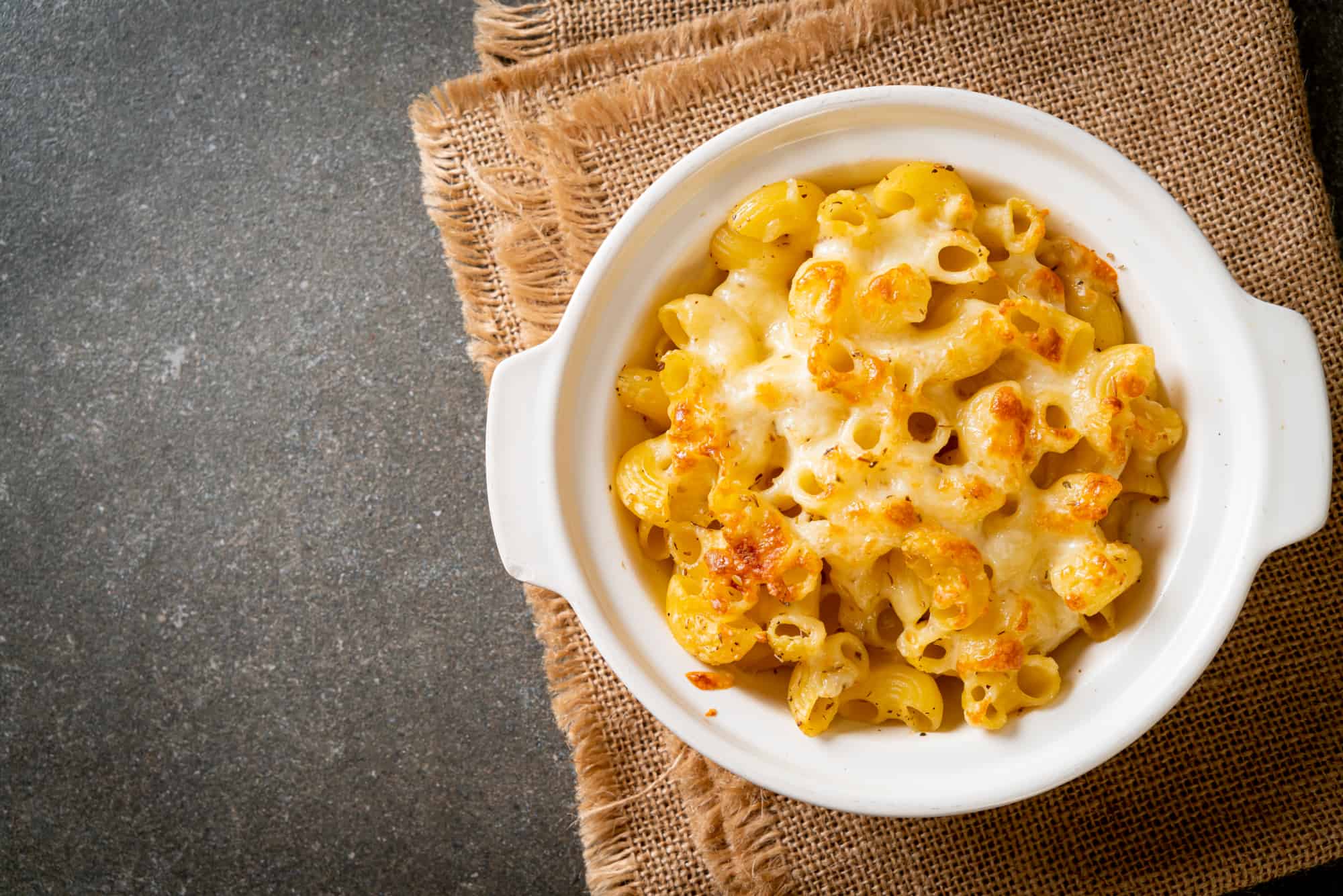low-carb macaroni and cheese in a white baking dish on a burlap table cloth