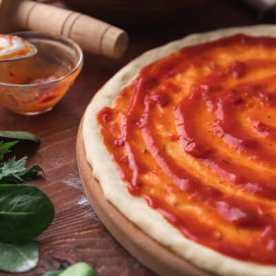 close up image of a low carb pizza base with low carb pizza sauce on top